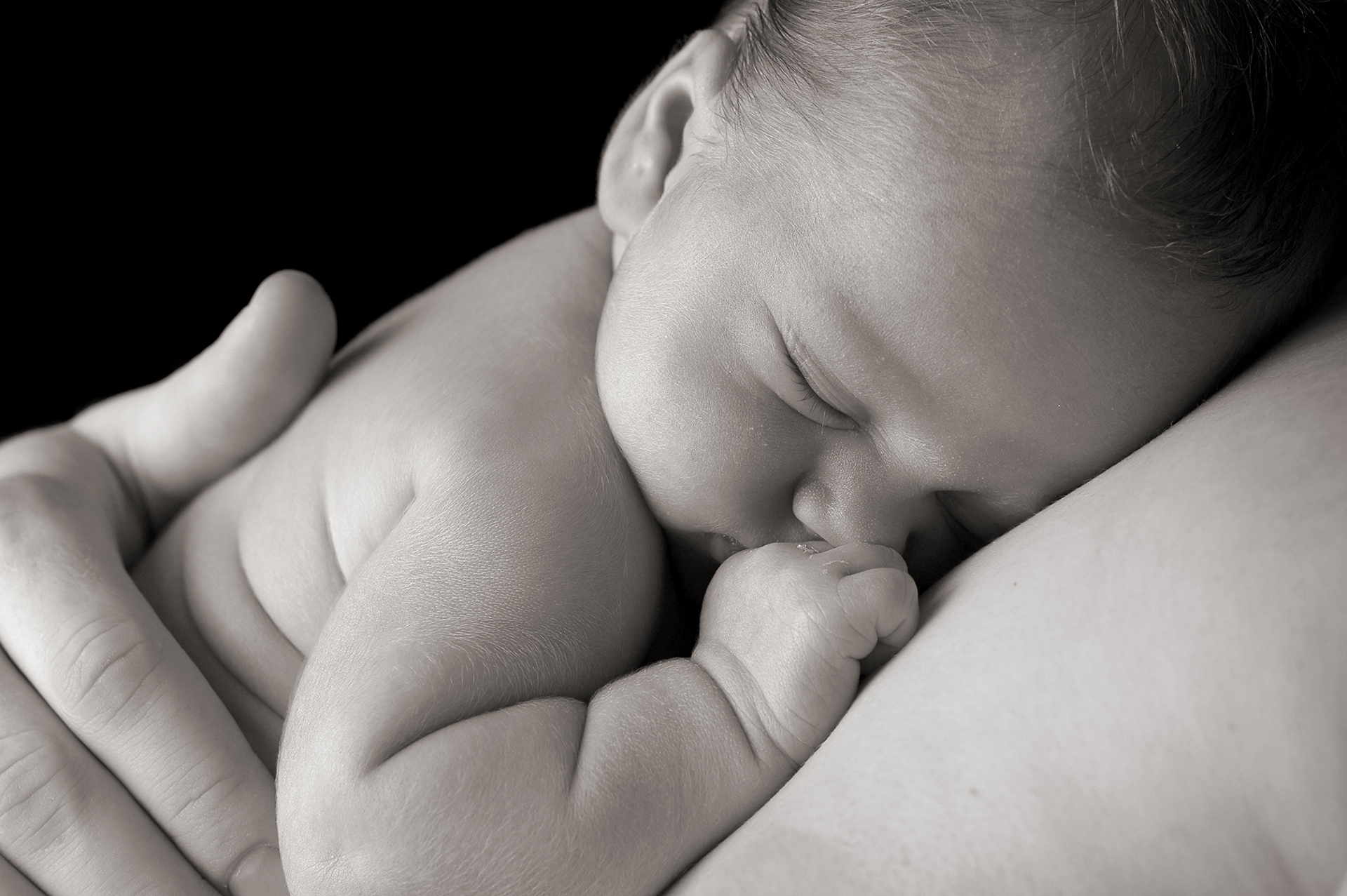 Portrait bébé nouveau-né en noir et blanc dans les bras d'une maman