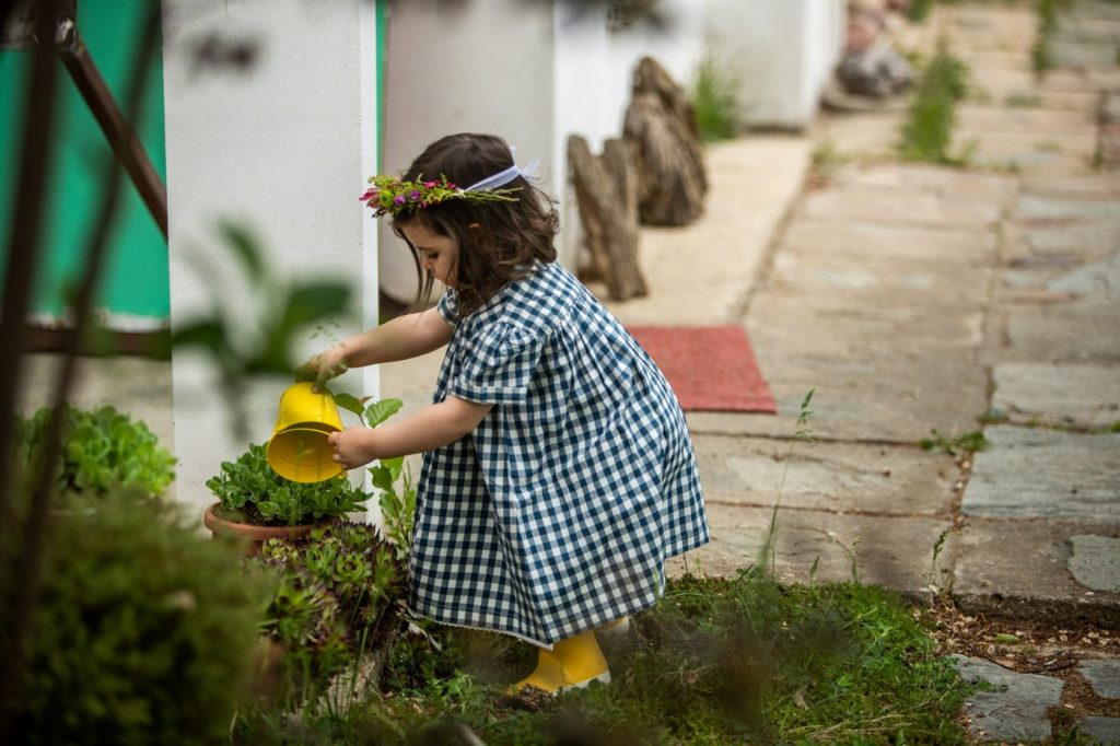 Une petite fille arrosant une plante