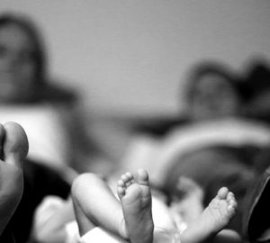 photo noir et blanc de pieds de jeunes parents avec leur bébé
