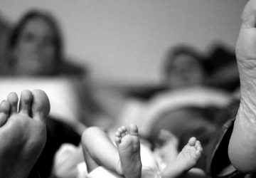 photo noir et blanc de pieds de jeunes parents avec leur bébé