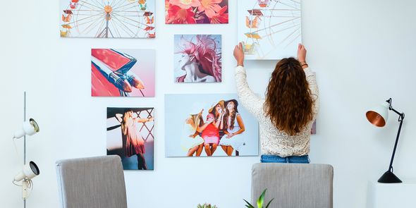 Décorer un mur de couleur avec un assortiment de cadres et de toiles pêle-mêle