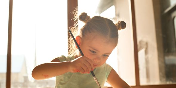 Petite fille en train de peindre et de dessiner : que faire de tous ses dessins d'enfants ?