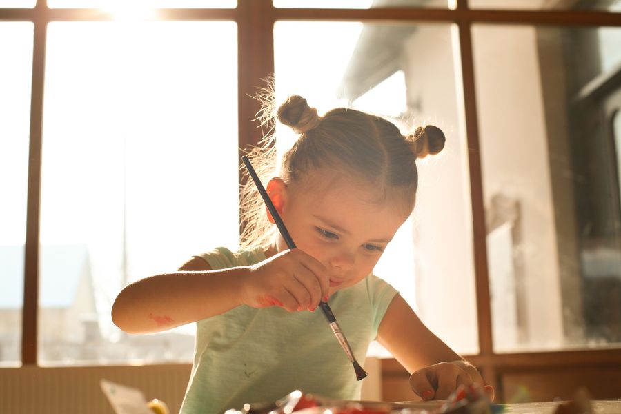 Petite fille en train de peindre et de dessiner : que faire de tous ses dessins d'enfants ?