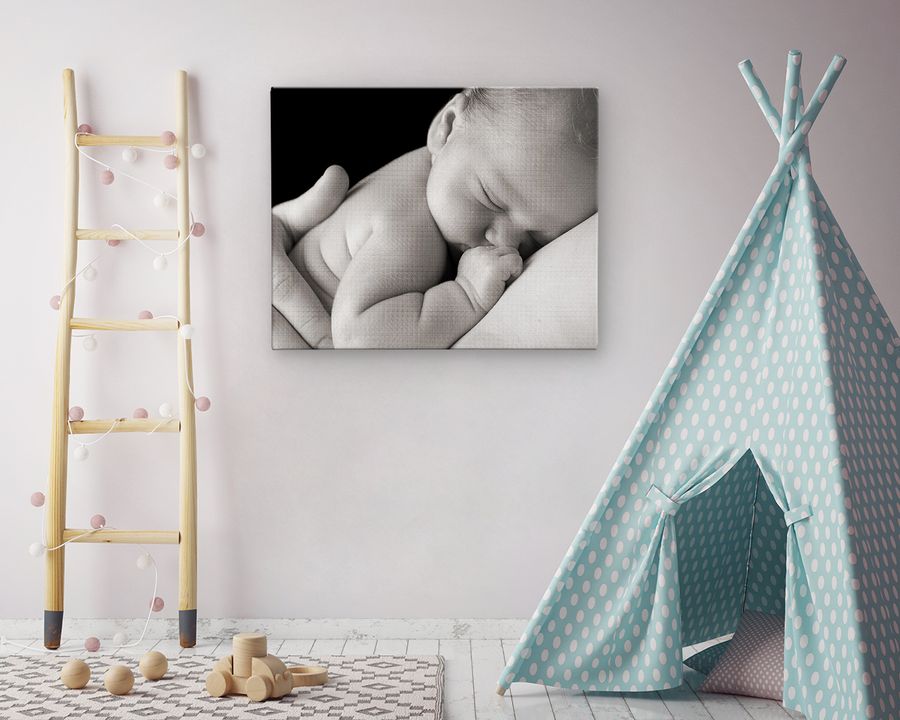 Chambre de bébé avec un portrait de nouveau-né au mur et un tipi bleu