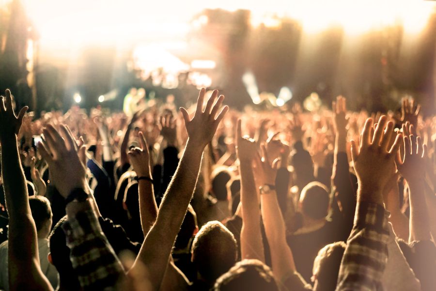 Foule mains levées dans la fosse d'un concert de musique