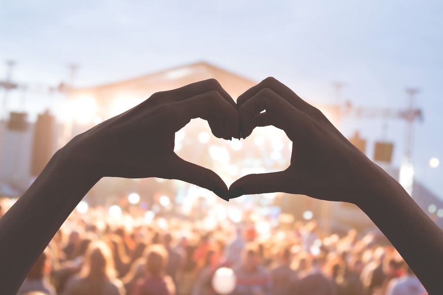 Mains en forme de coeur lors d'un concert de musique