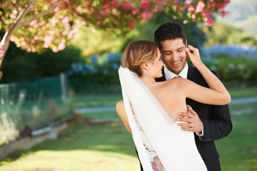 Mari et femme lors d'un mariage photographiés dans un parc ensoleillé