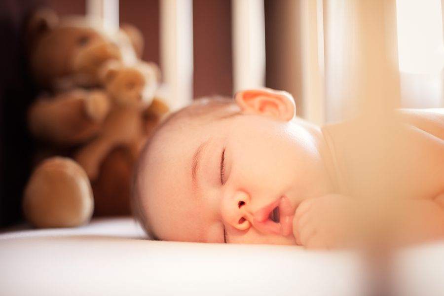 Bébé nouveau-né dans son lit à barreaux, photo couleur