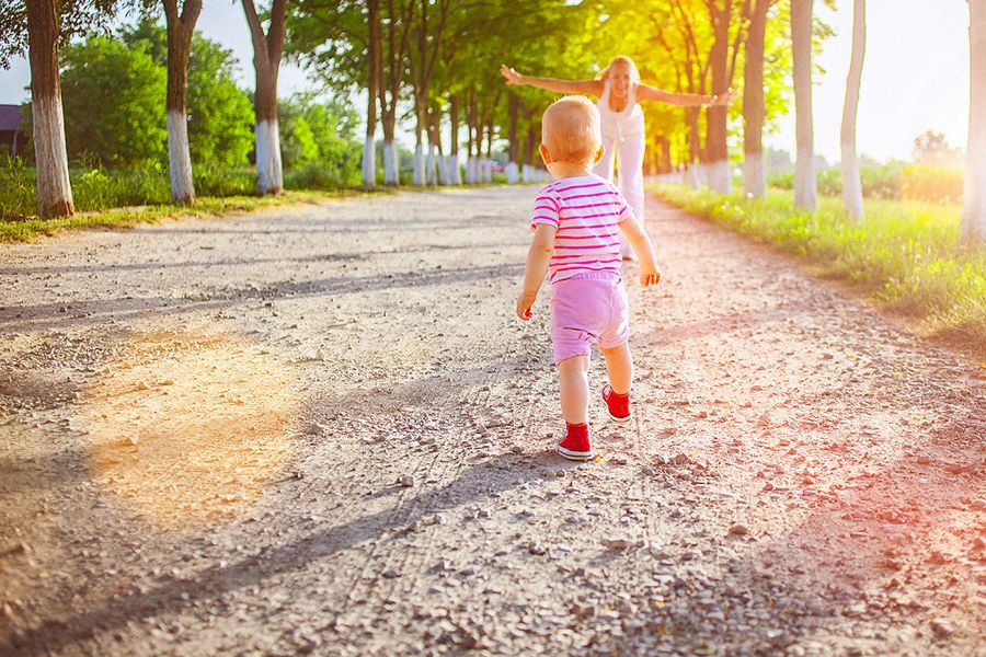 Premiers pas de bébé dehors, dans un parc, avec sa maman