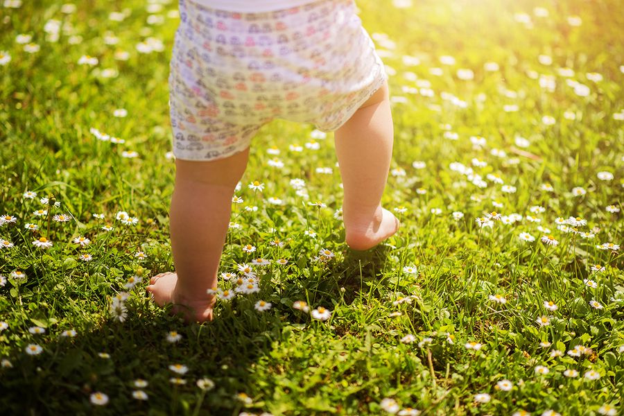 Les premiers pas de bébé dans l'herbe, dans un parc