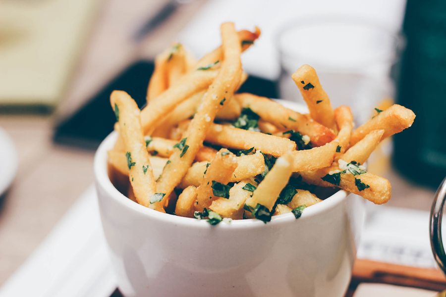 Photo culinaire de frites à la ciboulette dans un bol ou cornet blanc