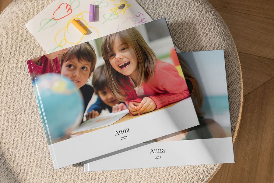 Deux livres photo superposés. La photo du haut est celle d'un enfant souriant en uniforme scolaire.