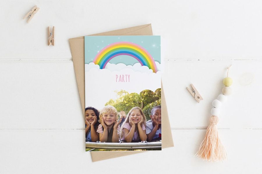 Carte d'anniversaire au design arc-en-ciel avec photo de quatre enfants allongés sur l'herbe sur le recto.