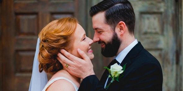 Une mariée et un marié se sourient dans les yeux le jour de leur mariage, la main du marié posée sur la joue de la mariée, pour inspirer des idées photos mariage issues de la checklist ultime des photos de mariage.
