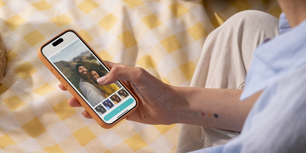 Gros plan d'une personne utilisant une application de filtre photo sur son smartphone, explorant les meilleures applications de retouche photo gratuites avec Photobox.