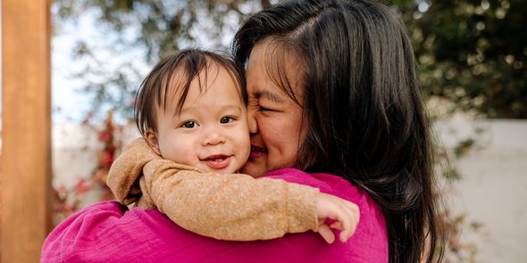 Une maman souriante qui câline son bébé ; une idée de cadeau Photobox pour une première fête des mères pour une jeune maman en 2026.