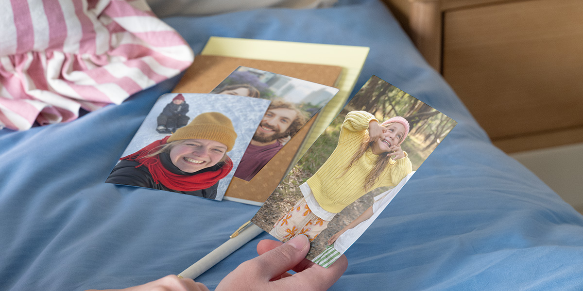 Une personne tenant des photos de famille pour comparer un tirage photo papier mat ou brillant.