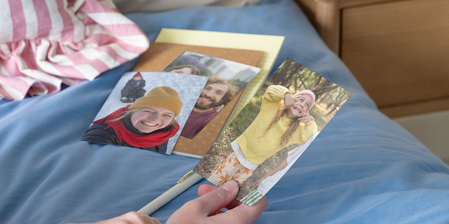 Une personne tenant des photos de famille pour comparer un tirage photo papier mat ou brillant.