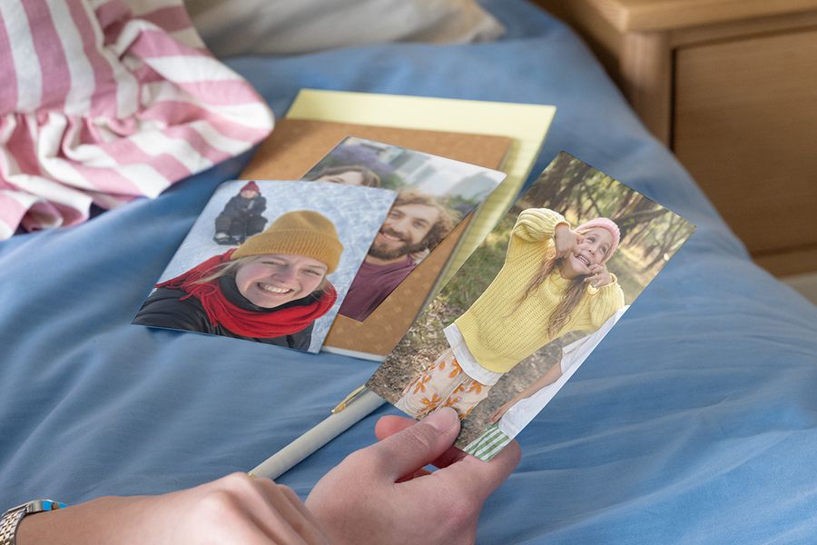 Une personne tenant des photos de famille pour comparer un tirage photo papier mat ou brillant.