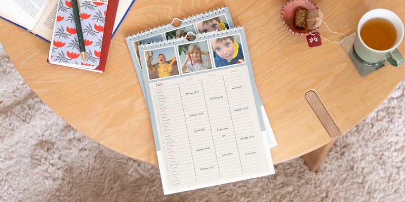 Agenda familiale Photobox personnalisée exposée en évidence sur une table basse en bois.