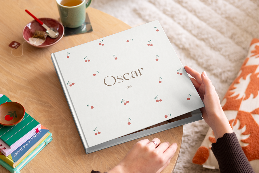 Une femme sur le point d'ouvrir mon premier livre photo de Photobox sur une table basse en bois.