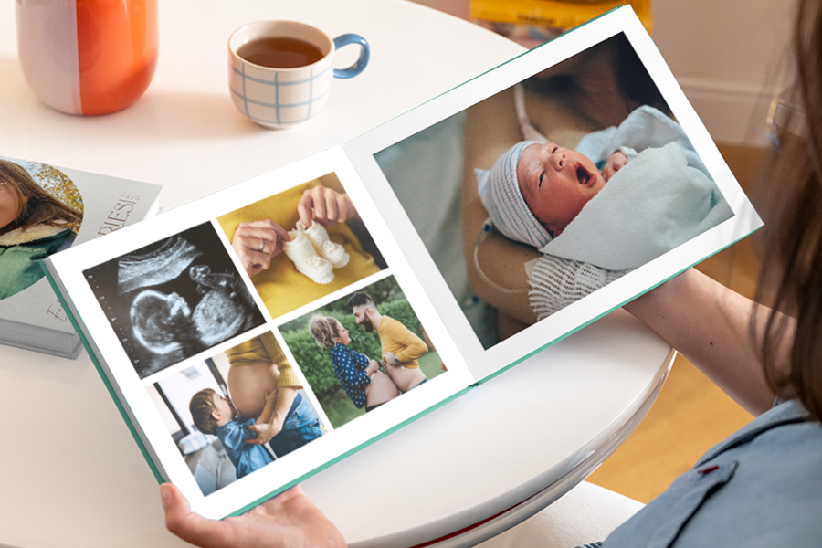 Un livre photo 1ere annee bebe ouvert montrant un ventre de grossesse, une échographie et des chaussons sur la page de gauche, et une photo de nouveau-né sur la droite.