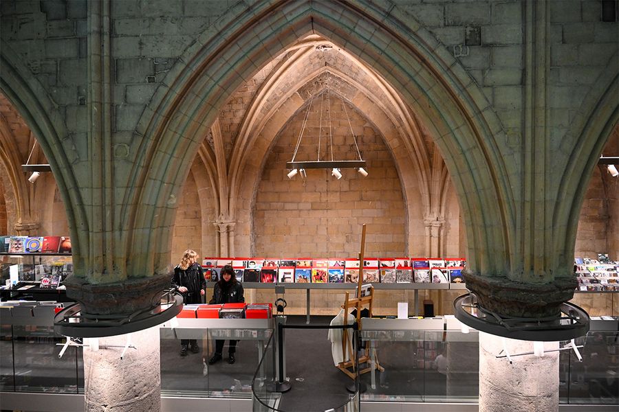 Boekhandel Dominicanen à Maastricht, une librairie située dans une église gothique de 700 ans avec de hautes étagères et des plafonds voûtés, pour un voyage littéraire avec Photobox.