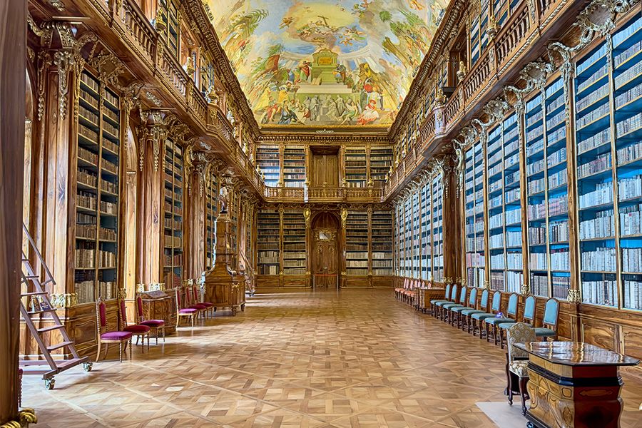 La salle philosophique de la bibliothèque du monastère de Strahov à Prague, aux plafonds vertigineux et boiseries en noyer, idéale pour un voyage littéraire avec Photobox.
