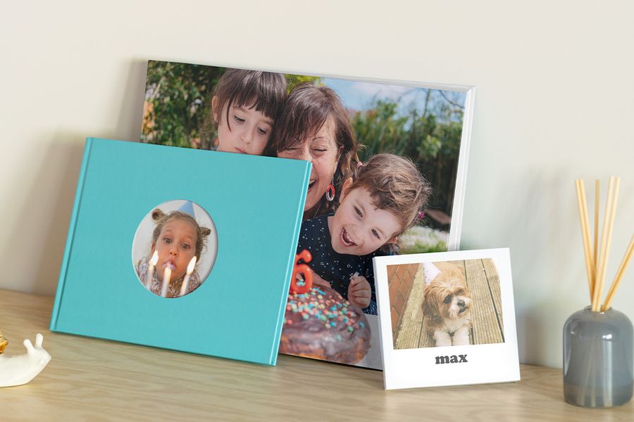 Trois modèles de livre photo anniversaire Photobox : un avec une grand-mère et ses petits-enfants, un livre photo pour anniversaire d'une petite fille soufflant des bougies et un livre photo personnalisé anniversaire avec le chien Max.