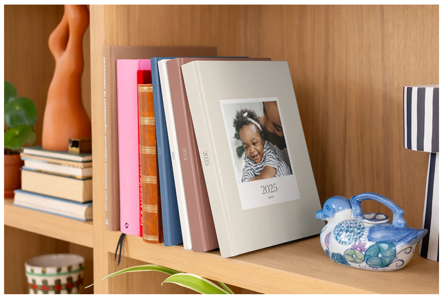 Une étagère avec des livres photo annuaires premium layflat à couverture rigide de Photobox, parfaits pour créer un album photo personnalisé de qualité.