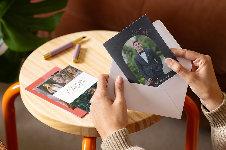 Une personne regardant des cartes de première communion personnalisées et des invitations pour préparer la 1ère communion avec Photobox.