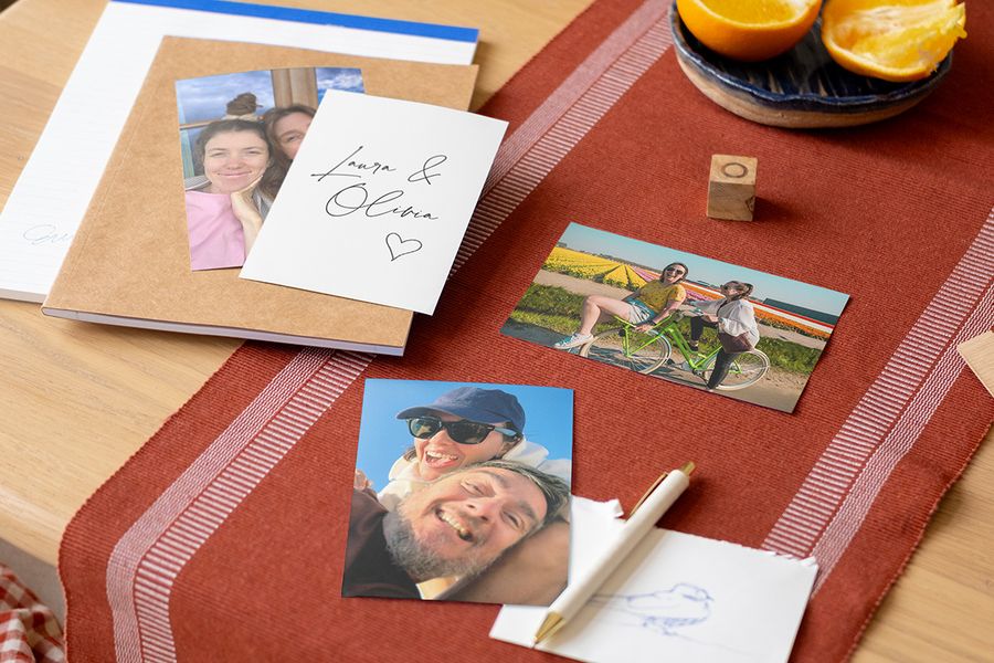Une sélection de tirages photo et de cartes personnalisées sur une table, illustrant la tendance du storytelling et les tendances mariage 2026 avec Photobox.