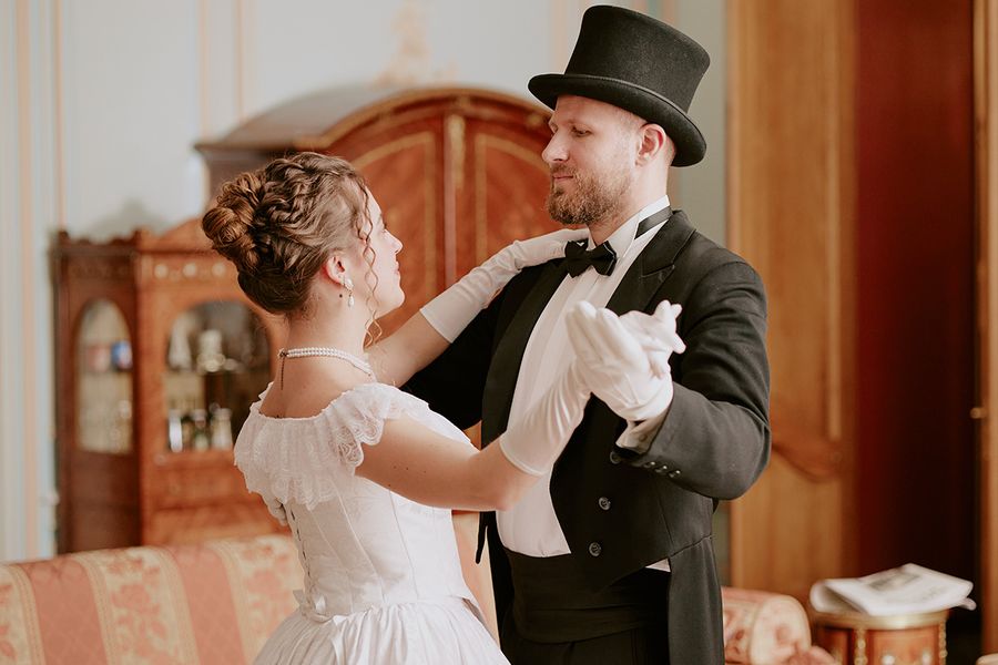 Une photo de mariage kitsch et rétro d'un couple portant des tenues de style Bridgerton, illustrant les tendances mariage 2026 et les nouveaux styles de robes de mariée avec Photobox.