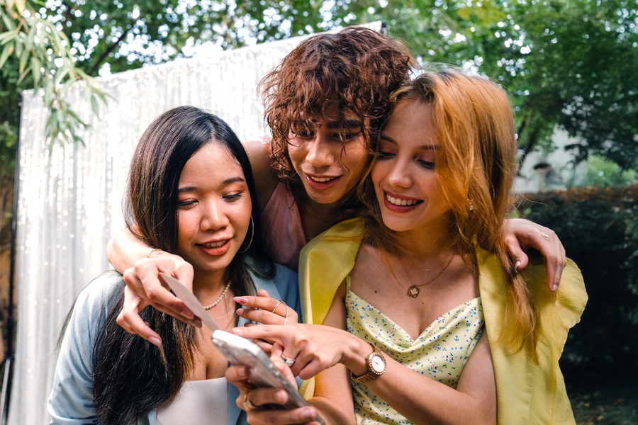 Trois amis en tenue élégante lors d’un mariage participent à une chasse au trésor photo de mariage, pour inspirer Photobox et des jeux mariage pour animer un mariage.