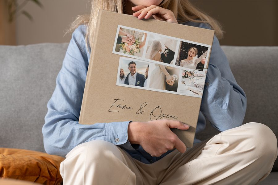 Une femme tient sur ses genoux un livre photo Photobox de mariage de type beau livre personnalisé, pour inspirer un beau livre photo de mariage et un livre photo décoratif personnalisé.