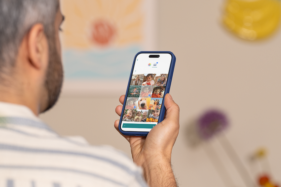 Une personne utilise l’application mobile Photobox sur son téléphone pour créer un produit photo personnalisé, pour inspirer une création livre photo facile et une création livre photo en ligne.