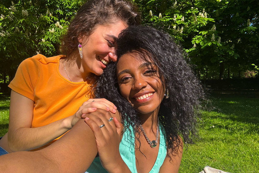 Deux femmes souriantes prennent un selfie dans un parc luxuriant et verdoyant, illustrant comment des couleurs vives peuvent rendre les photos au soleil plus éclatantes et pleines de vie.