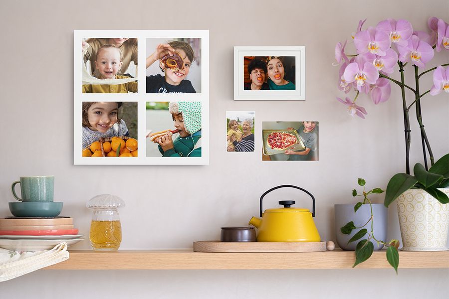 Une étagère en bois décorée d’objets chaleureux est placée sous un collage photo personnalisé d’enfants, un tirage photo encadré amusant et deux tirages photo de famille, illustrant des idées de décoration murale avec des photos.