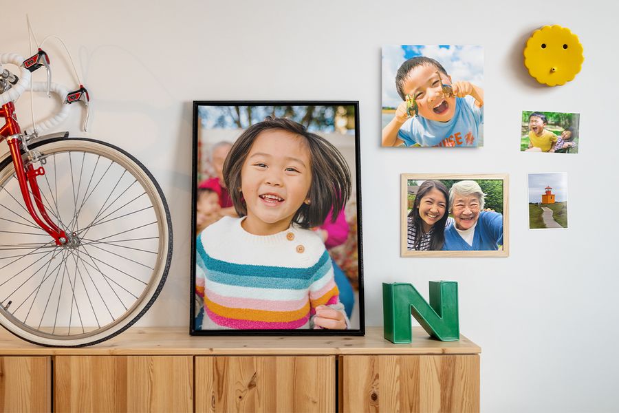 Diverses photos de famille sont présentées dans différentes compositions sur un mur, aux côtés d’objets déco et de suspensions murales, pour inspirer une décoration murale photo et un rafraîchissement printanier de la maison.