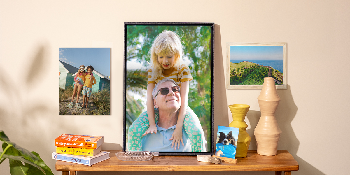Une sélection de tirages photo Photobox présentés dans la maison, avec un tirage photo de chien sur une table d’appoint, un poster mural d’enfants et deux photos encadrées, pour inspirer des tirages photo muraux et une décoration printanière.