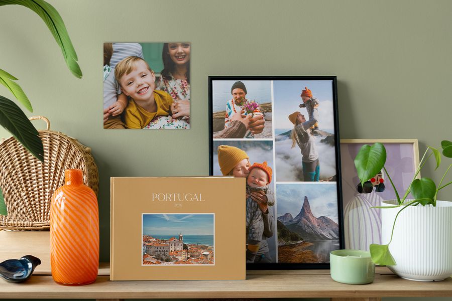 Un livre photo de voyage personnalisé est posé à côté d’un collage photo encadré et d’un tirage photo de famille au mur, pour inspirer des façons de rendre son intérieur plus chaleureux avec une décoration photo pleine de sens.