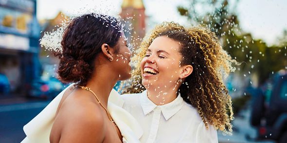Un couple souriant le jour de son mariage, pour inspirer un texte de carte de mariage et des idées de messages pour une carte de mariage.