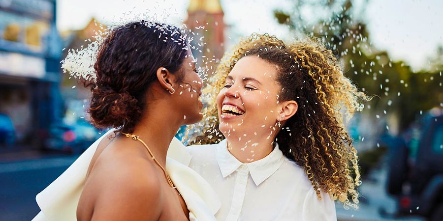Un couple souriant le jour de son mariage, pour inspirer un texte de carte de mariage et des idées de messages pour une carte de mariage.