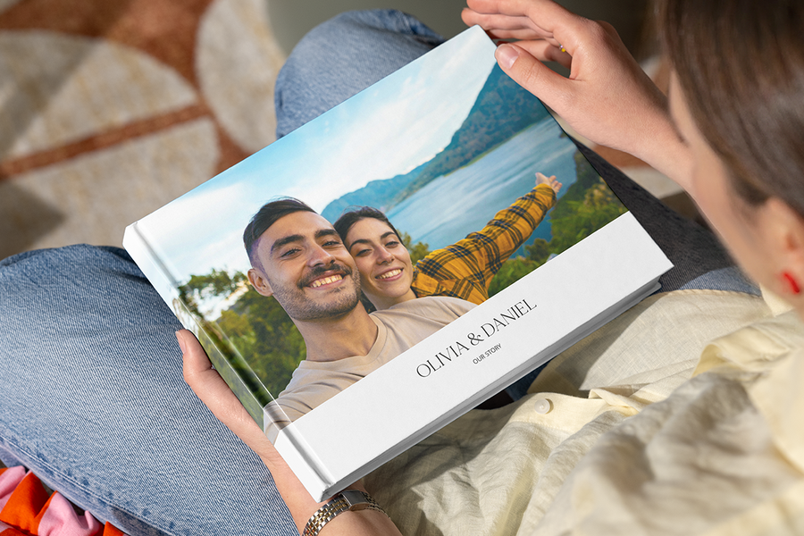 Un livre photo personnalisé Photobox avec un couple heureux dans un lieu pittoresque sur la couverture, illustrant la surprise d’un livre photo comme idée de demande en mariage romantique.