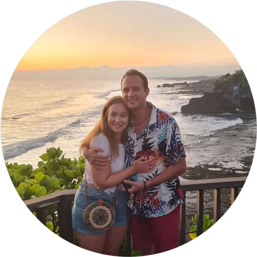 Claudia et son mari sourient ensemble devant un magnifique coucher de soleil à Bali, illustrant son histoire de demande en mariage.