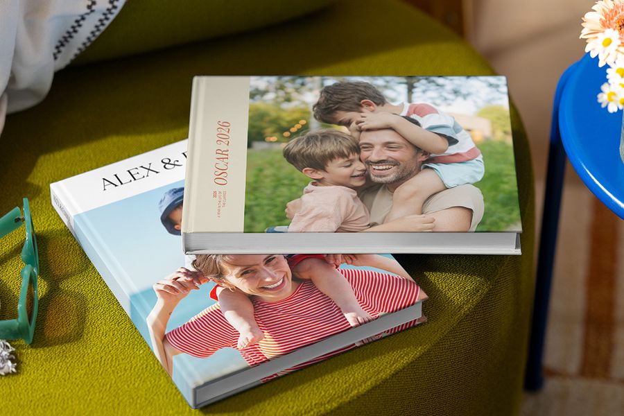 Deux livres photo vacances Photobox différents avec des photos de famille sur les couvertures, montrant des parents, des enfants, un nom et l’année, illustrant les bonnes pratiques pour créer un livre photo voyage personnalisé.