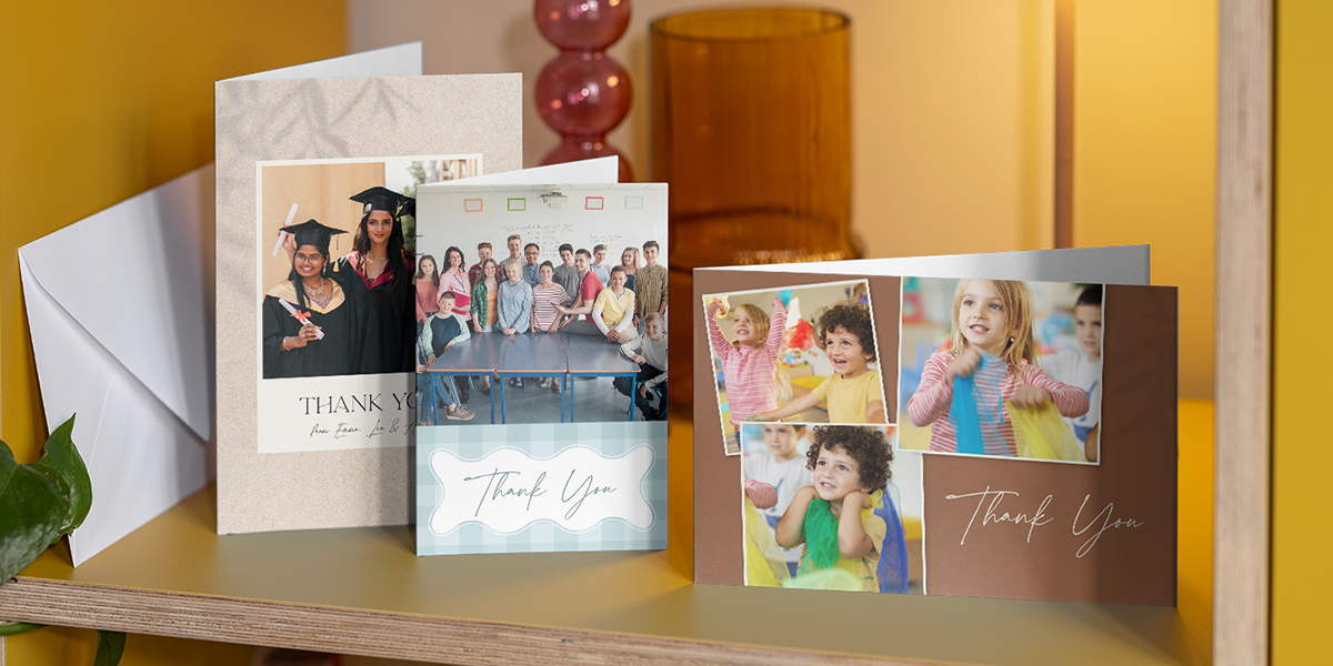 Une sélection de cartes merci prof personnalisées Photobox est présentée côte à côte sur une étagère, pour inspirer un message de remerciement pour prof simple, sincère et de fin d’année.