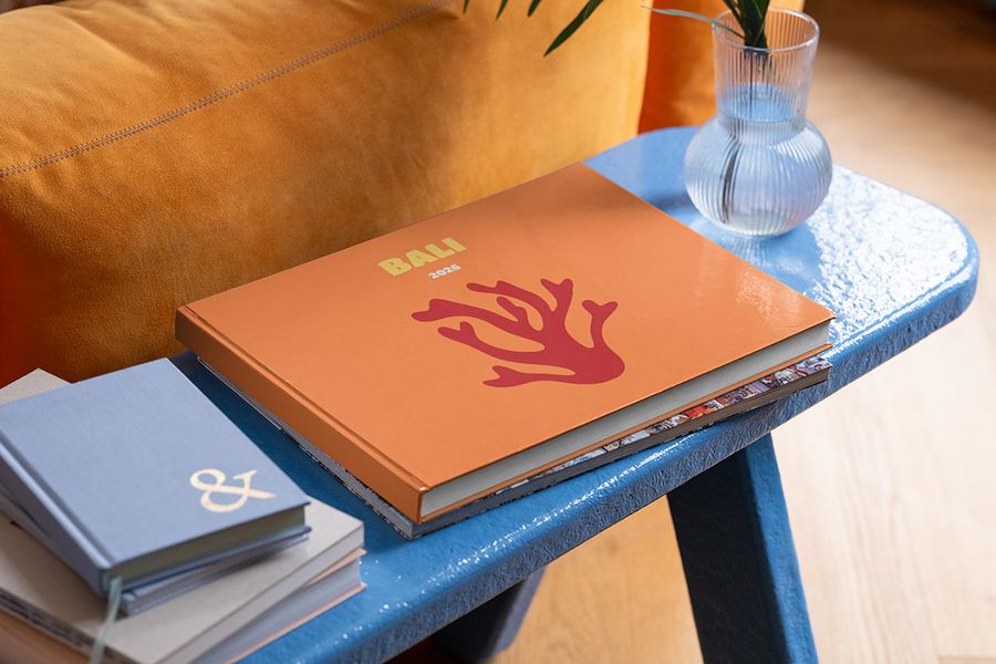 Un livre photo de voyage personnalisé Photobox au format paysage sur Bali est posé sur une table basse bleue, pour inspirer une déco de table basse d’été et les touches finales de votre déco d’été maison.