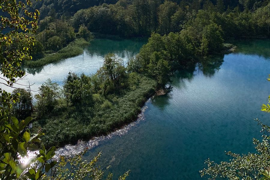 Des cascades émeraude et des passerelles en bois au-dessus d'une eau turquoise au parc national des lacs de Plitvice en Croatie, l'un des plus beaux parcs nationaux d'Europe présentés dans le guide de Photobox.