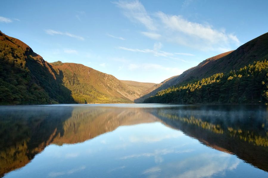 Des pentes couvertes de bruyère et le célèbre lac Lough Tay, surnommé « lac Guinness », au parc national des monts Wicklow en Irlande, l'un des légendaires parcs naturels d'Europe présentés dans le guide de Photobox.